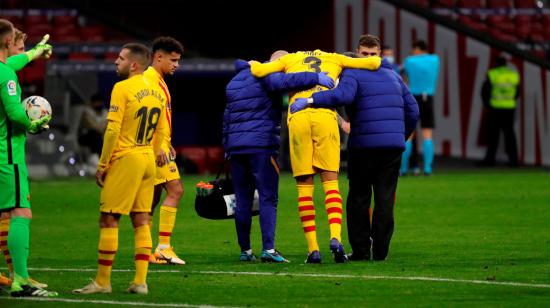El defensa del FC Barcelona, Gerard Piqué, se retira lesionado del terreno de juego tras una jugada.