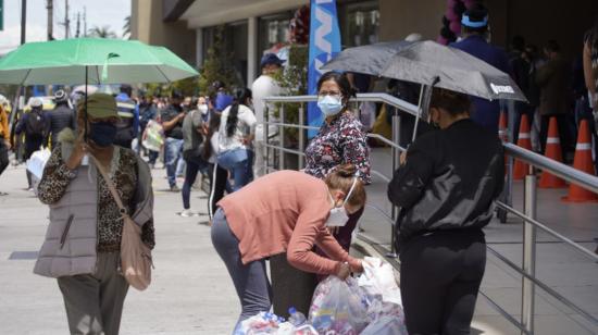 Ciudadanos hacen filas en los exteriores de un centro comercial de Quito, el miércoles 25 de noviembre de 2020.