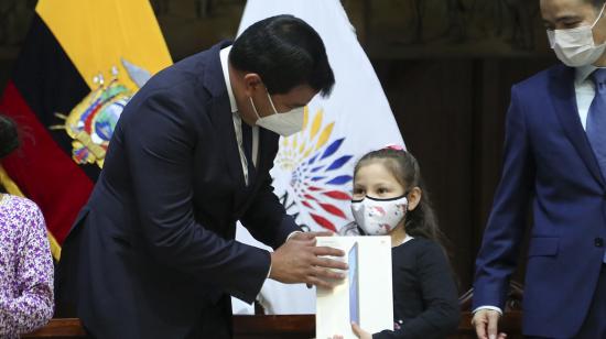 El presidente de la Asamblea, César Litardo, entrega una tablet a una niña el 11 de septiembre de 2020.