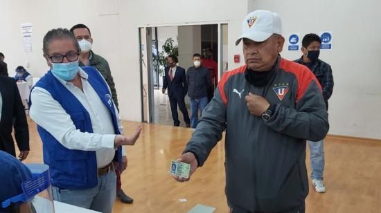 Un ciudadano se retira la mascarilla para verificar su identidad en el simulacro de las elecciones, realizado el 15 de noviembre de 2020 en Quito.