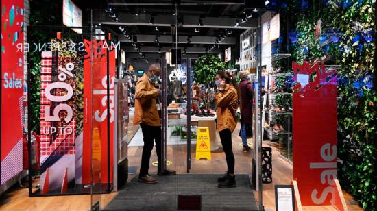 Ciudadanos conversan en la puerta de una tienda en Londres, el 19 de diciembre de 2020.