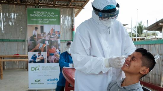 Un trabajador de la salud realiza una prueba PCR a una persona en un barrio de Guayaquil, el 18 de diciembre de 2020. 