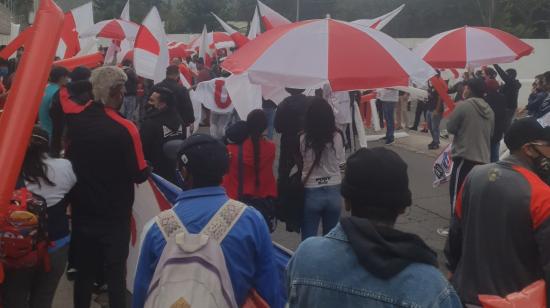 Hinchas de Liga de Quito despiden al equipo con banderas del Complejo de Pomasqui, el martes 22 de diciembre de 2020. 