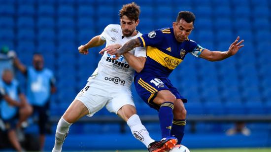 Carlos Tévez disputa un balón con Luan Peres de Santos, en la semifinal de ida de la Copa Libertadores en La Bombonera, el 06 de enero de 2021.