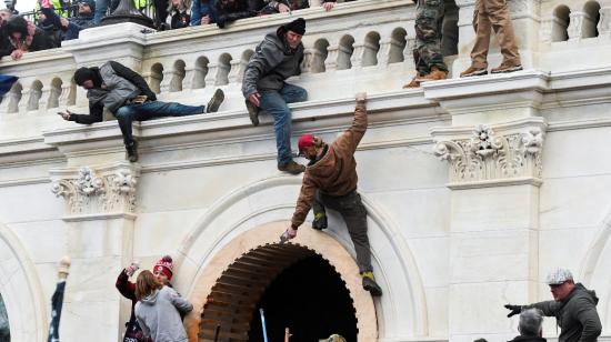 Partidarios de Donald Trump subiendo por las paredes del Capitolio de los Estados Unidos durante una protesta contra la certificación de los resultados de las elecciones, en Washington, EEUU, el 6 de enero de 2021.