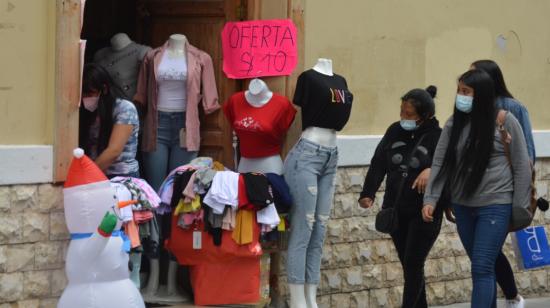 Mujeres caminan afuera de un local de ropa en Cuenca, el 23 de diciembre de 2020. 