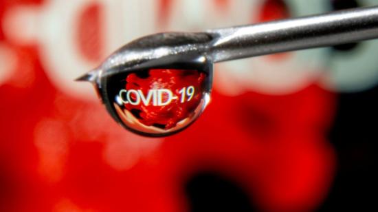 La palabra "Covid-19" se refleja en una gota en la aguja de una jeringa. 9 de noviembre de 2020.