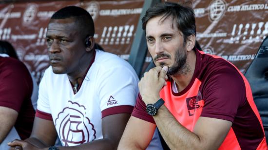 Carlos Gruezo y Luis Zubeldía observan el partido entre Lanús y Universidad Católica de Ecuador por Copa Sudamericana, el 12 de febrero de 2020, en Buenos Aires.