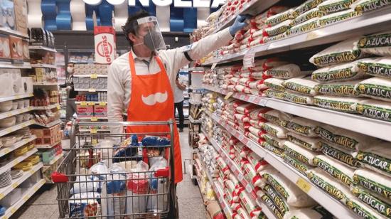 Un trabajador de una aplicación selecciona los productos pedidos por el consumidor en un supermercado. 