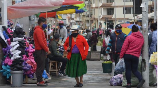 Personas trabajan en un mercado en Cuenca, 