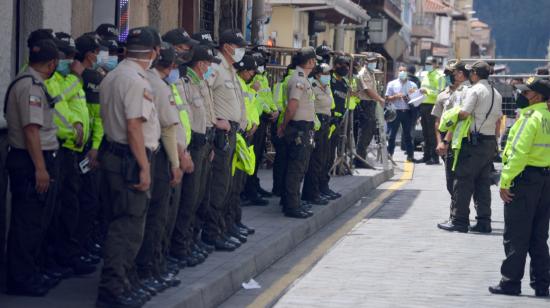 Uniformados, vallas y un vehículo antimotines se ubicaron en los exteriores de la oficina del CNE en Cuenca, el 8 de febrero de 2021.