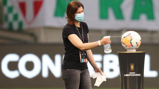 Una colaboradora de Conmebol desinfecta una pelota antes de un partido por Copa Libertadores, en febrero de 2021.