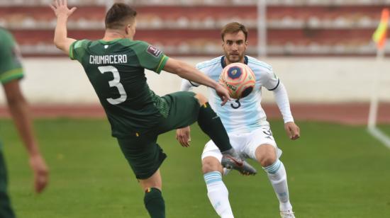 Alejandro Chumacero disputa un balón con Nicolás Tagliafico de Argentina, durante un partido de las Eliminatorias al Mundial de Catar, entre los seleccionados de Bolivia y Argentina, en el Estadio Hernando Siles, en La Paz, el 13 de octubre de 2021.