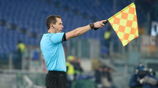 Un juez de línea levanta la bandera marcando un fuera de juego en el partido.