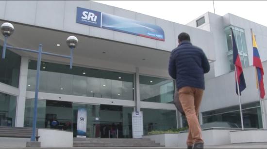 Una persona camina en los exteriores de una agencia del SRI, en Quito.