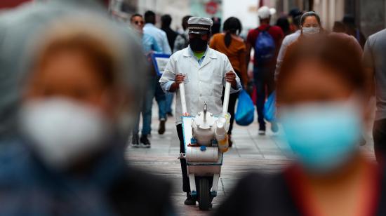 Un hombre recorre las calles mientras vende sus productos el 23 de abril de 2021, en Quito.