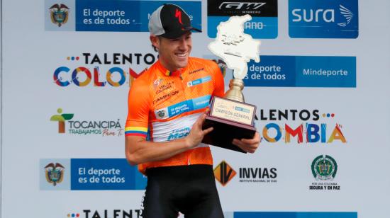 El ciclista José 'Tito' Hernández, del Team Medellín, levanta el trofeo de campeón de la Vuelta a Colombia 2021, en Bogotá, el domingo 25 de abril.