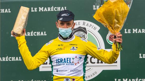 Michael Woods de Israel Start-Up Nation celebra en el podio con el maillot amarillo de líder general después de ganar la cuarta etapa del Tour de Romandía, el sábado 1 de mayo de 2021.