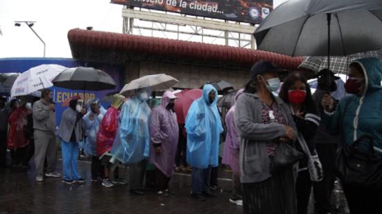 Adultos mayores esperan  ser vacunados, bajo la lluvia, en el Centro de Exposiciones Quito.