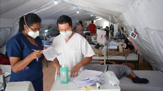 Dos médicos del Hospital Quito Sur en las carpas militares que funcionan en el parqueadero del hospital, el 1 de mayo de 2021.