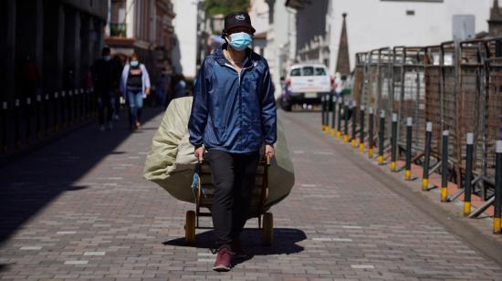 Un trabajador informal camina  en el Centro Histórico de Quito, el 20 de mayo de 2021. 