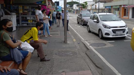 Personas esperan un bus en Guayaquil, el 21 de mayo de 2021.