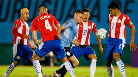 Jonathan Rodríguez, de Uruguay, disputa una pelota con los seleccionados paraguayos en la Fecha 7 de las Eliminatorias, el jueves 3 de junio de 2021.