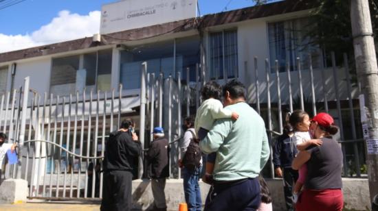 Padres con sus hijos en las afueras del Centro de Salud de Chimbacalle, en el sur de Quito, el 17 de junio 2021.