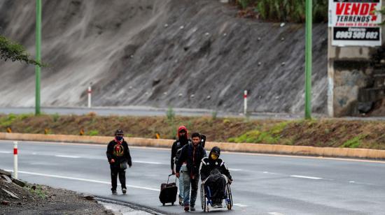 Ciudadanos venezolanos, uno de ellos con discapacidad, transitaban el 28 de mayo de 2020 en una carretera cercana a Quito (Ecuador).