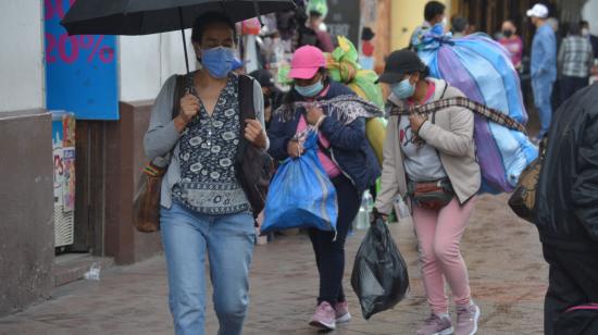 Dos mujeres cargan mercadería en el centro de Cuenca, el 14 de abril de 2021. 