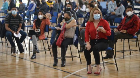 Personas esperan su turno para recibir la vacuna contra el Covid-19, en el coliseo de la Universidad Salesiana de Quito, el 19 de junio de 2021.