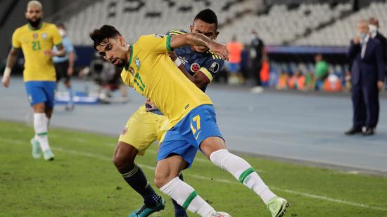 Lucas Paquetá, de Brasil, disputa el balón con William Tesillo de Colombia, en un partido por Copa América, el 23 de junio de 2021.