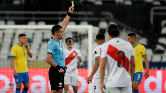 El árbitro chileno Roberto Tobar amonesta a Yoshimar Yotún de Perú, durante el compromiso frente a Brasil por las semifinales de la Copa América en el estadio Olímpico Nilton Santos, el lunes  5 de julio de 2021.