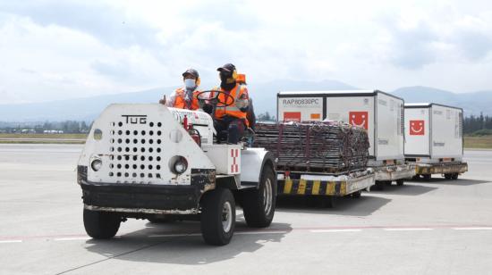 Trabajadores del aeropuerto Mariscal Sucre de Quito conducen un vehículo con dosis de la vacuna Sinovac, el 9 de julio de 2021.