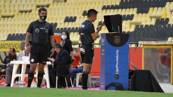 El árbitro Luis Quiroz se acerca al monitor del VAR en el partido Barcelona-Emelec, el sábado 10 de julio de 2021.