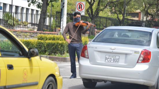 En Cuenca, un hombre se gana unos centavos tocando su violín, el 10 de abril de 2020.