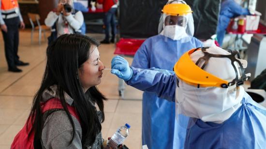 Personal médico hace pruebas PCR para identificar  a posibles pacientes con Covid-19 en el aeropuerto de Quito, el 16 de julio de 2021.