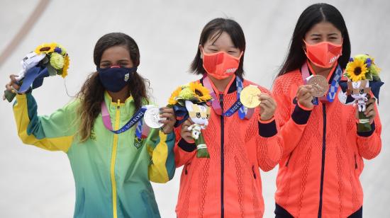 Rayssa Leal (i), Momiji Nishiya (c) y Funa Nakayama (d), levantan sus medallas en la ceremonioa de premiación de skate femenino en Tokio, el 26 de julio de 2021.