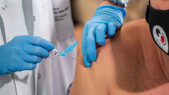 Personal médico inyecta una vacuna a un paciente.