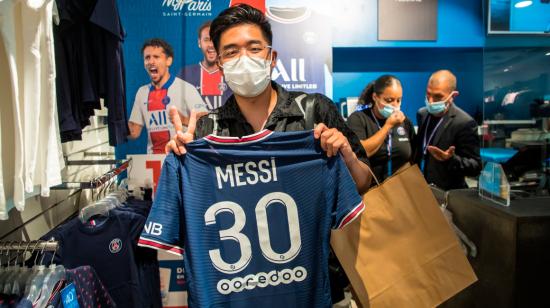 Un aficionado posa con la camiseta de Messi dentro de la tienda del PSG. 