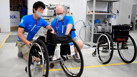 Técnicos reparan una silla de ruedas en el  taller de la Villa Paralímpica de Tokio.