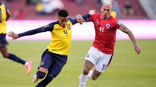 Byron Castillo de Ecuador disputa un balón con Eduardo Vargas de Chile, el domingo 5 de septiembre de 2021, en Quito.