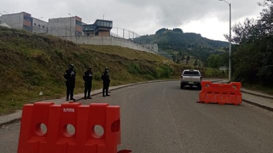 Tres policías controlan el trásnito vehicular en los exteriores de la cárcel de Turi, en Cuenca, el 23 de septiembre de 2021.