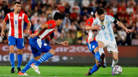 Lionel Messi disputa un balón con los jugadores de Paraguay en la Fecha 11 de las Eliminatorias al Mundial de Catar, el jueves 7 de octubre de 2021.