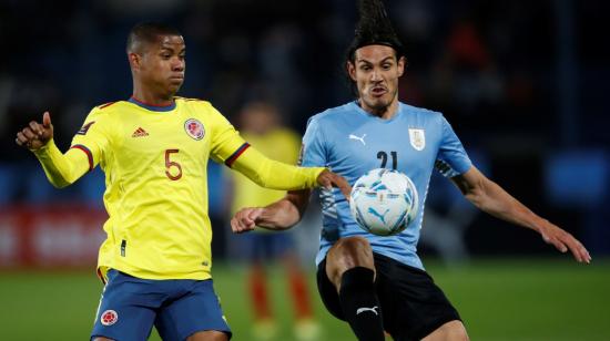 Edinson Cavani de Uruguay disputa un balón con Wilmar Barrios de Colombia, este jueves 7 de octubre de 2021, durante un partido por las Eliminatorias sudamericanas para el Mundial de Catar 2022, en el estadio Gran Parque Central en Montevideo.