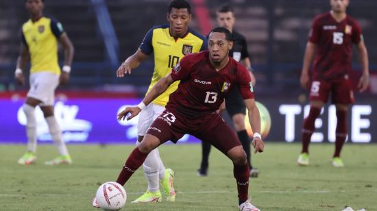 José Martínez de Venezuela disputa el balón con Gonzalo Plata de Ecuador, durante un partido por las Eliminatorias sudamericanas al Mundial de Catar 2022, en el Estadio Olímpico de la UCV en Caracas, el domingo 10 de octubre de 2021.