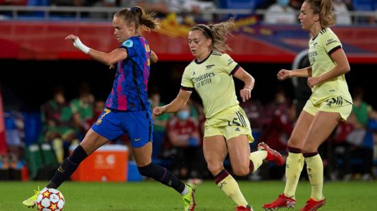 La delantera noruega del FC Barcelona, Caroline Graham Hansen (i), controla el balón ante las jugadoras del Arsenal, la irlandesa Katie McCabe (c) y la suiza Lia Walti, durante el encuentro correspondiente a la fase de grupos de la Champions League disputado el 5 de octubre de 2021 en el estadio Johan Cruyff, en la ciudad deportiva de Sant Joan Despí.