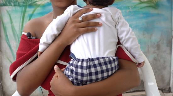 Niña de 14 años sostiene a su bebé de tres meses, mientras escucha la charla sobre maternidad. Guayaquil, 21 de octubre de 2021.