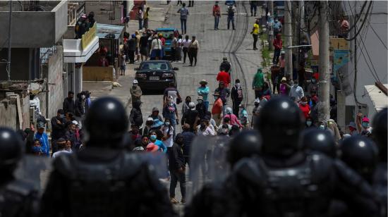 Manifestantes se enfrentan con agentes antidisturbios durante las movilizaciones contra los precios de los combustibles, en el norte de Quito, el 27 de octubre de 2021. 