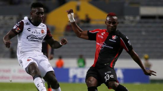 Julián Quiñones (d) de Atlas disputa el balón con Erick Castillo de Xolos, este jueves 28 de octubre de 2021 durante un partido de la jornada 16 del Torneo Apertura 2021 del fútbol mexicano disputado en el Estadio Jalisco en Guadalajara.